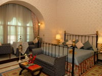 Historic suite with iron bed and arched wall