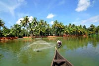 Fisherman casting a net from a canoe on the backwater