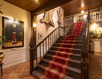 Staircase with red runner and mounted trophies