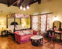 Room with canopied bed and pink sofa