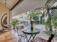 Cobbled central courtyard with parasols, cafe tables and a hanging wicker chair