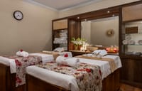 Twin treatment beds with rolled towels and flowers in the spa room