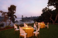 Tables laid on the lawn at dusk above the Betwa