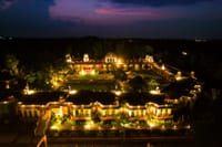 The property lit at night from above, showing the courtyard layout