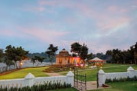 Stone cenotaph on the lawn at dusk with the river beyond