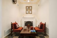 In room sitting nook with two armchairs and a fireplace