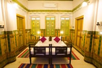 Bedroom with green shuttered doors and painted dado