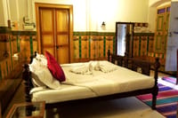 Bedroom with carved wooden door and painted dado