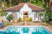 Moroccan Pool House, the pale-blue stand-alone house with scrolled gable and shuttered doors beside the pool at Amrapali House of Grace, Goa