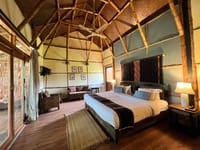 A cottage bedroom under a vaulted bamboo roof
