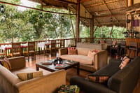 The lounge with sofas, low tables and the dining room behind