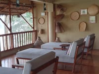 Loungers on a covered verandah hung with cane baskets