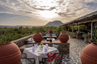 Rooftop dining terrace laid for dinner facing the hills