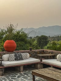 Stone lounge terrace with day beds facing the Aravallis