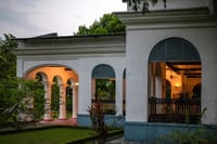 Arched verandah with lit interiors at twilight