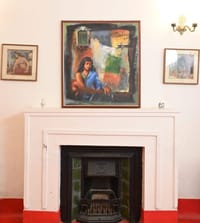 Marble fireplace hung with framed paintings