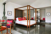 Room with teak four poster bed and carved pillars
