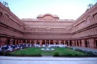 Arcaded inner courtyard with lawn and event tables at twilight