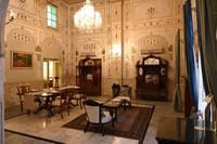 Ornate dining room with painted walls, crystal chandelier and antique sideboards