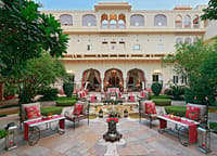 Evening dining tables set in the main courtyard beneath the haveli's arched facade