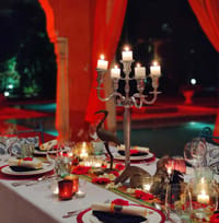 Candlelit private dining table with candelabra beside the pool