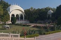 White garden pavilion and rose beds