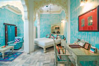 Turquoise painted room with white bed