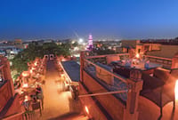 Rooftop restaurant lit at night above the city