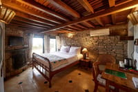 Bedroom with stone wall and timber ceiling