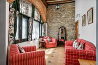 Sitting room with red sofas and stone wall