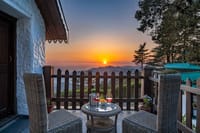 Balcony chairs facing sunset over the ridge
