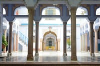 Blue-columned courtyard colonnade with painted archway