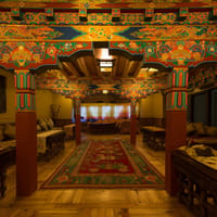 Dining hall with intricately painted beams, columns and dragon motifs, low tables and Tibetan carpets at Stok Palace Heritage, Leh