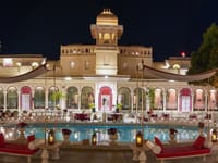 Lit palace and swimming pool at night