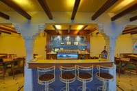 Bar counter with carved stone pillars and stools