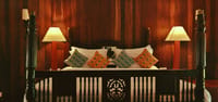 Four poster bed against rosewood panelling