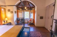 Bedroom with arched bay window nook and cane chair