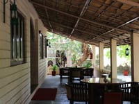 Covered verandah with dark wood seating and lanterns