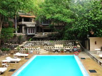 Swimming pool with loungers below stone terraces