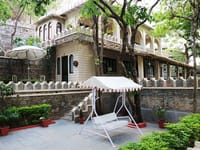 Stone building with jharokha balconies and a canopied swing
