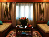 Sitting room with twin daybeds and gold curtains