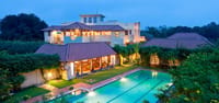 Mansion and lit pool at dusk