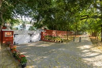 The white gate of 39 Prithviraj Road under the trees, Lutyens Bungalow, New Delhi