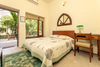 A double room with the garden through the window, arched mirror above the bed, Lutyens Bungalow, New Delhi