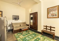 A sitting area with a daybed, fridge, TV and a painted elephant, Lutyens Bungalow, New Delhi