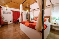 A four-poster bed and a sitting corner in one of the cottages