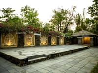 The stone facade and its water channel, bougainvillea over the wall