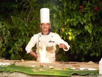 The chef laying out dinner on a banana leaf