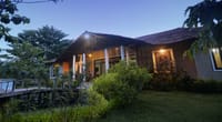 The lodge at dusk, its windows lit