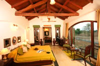 A bedroom under the timber roof, opening to the garden